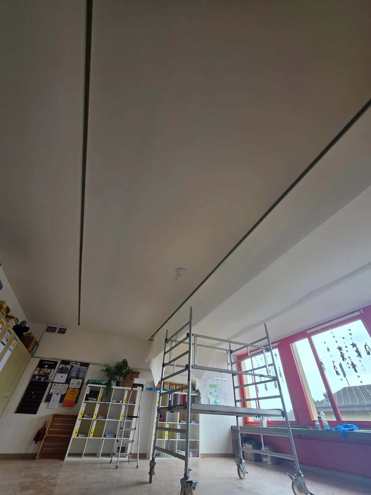 Montage: Rollgerüst im Klassenzimmer unter der fertig gespannten Akustikdecke